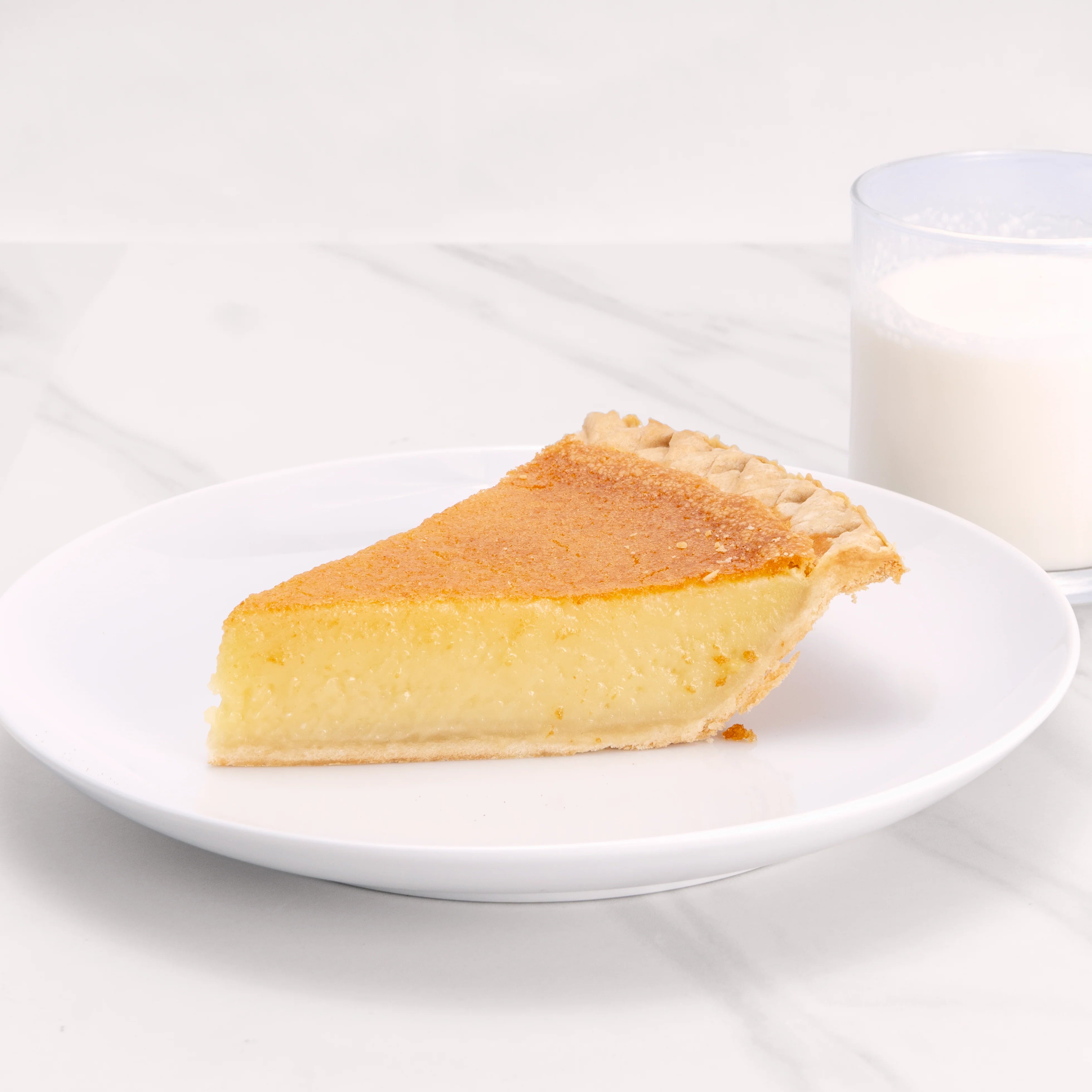 Slice of Buttermilk Chess pie with a glass of milk.