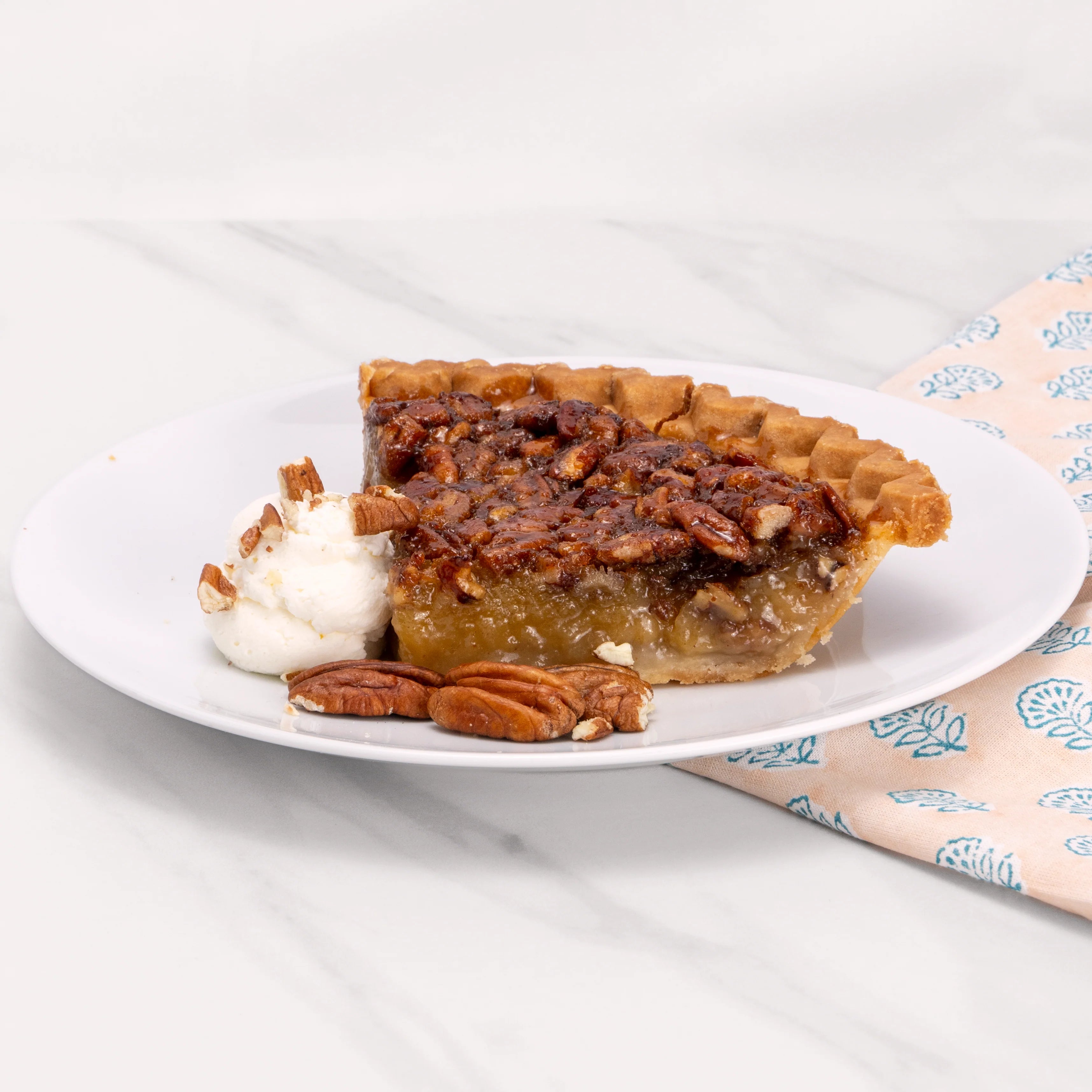 Slice of Gluten Free Pecan Pie garnished with pecans and crème.