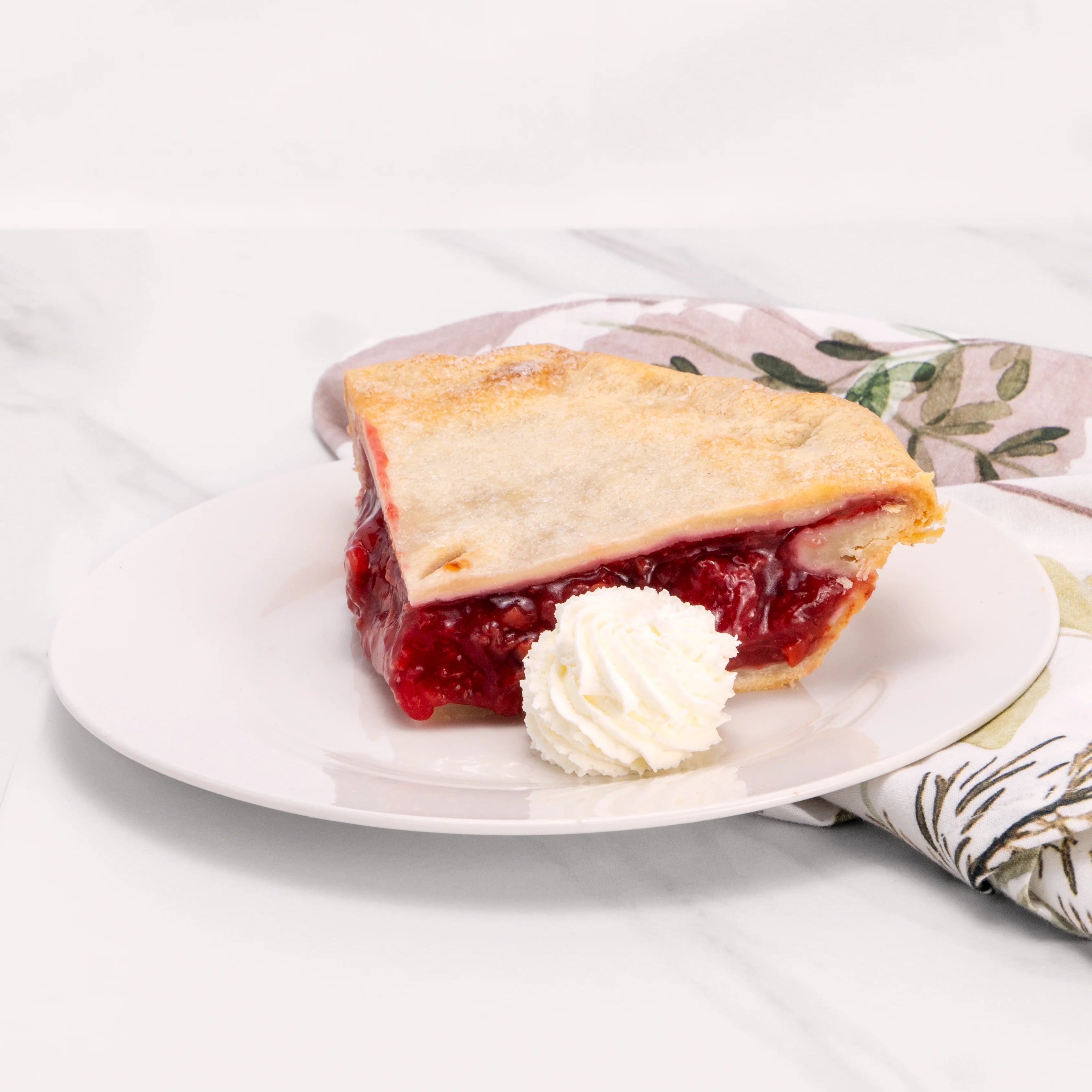 Slice of Lower Sugar Cherry Pie garnished with a dollop of crème.