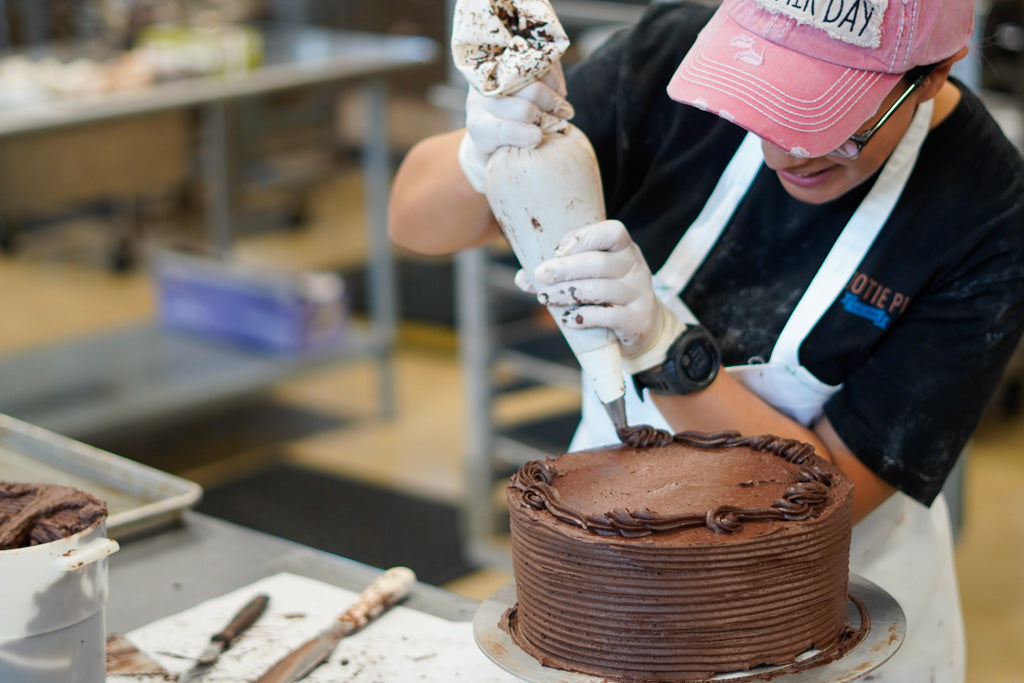 Employee icing a cake.