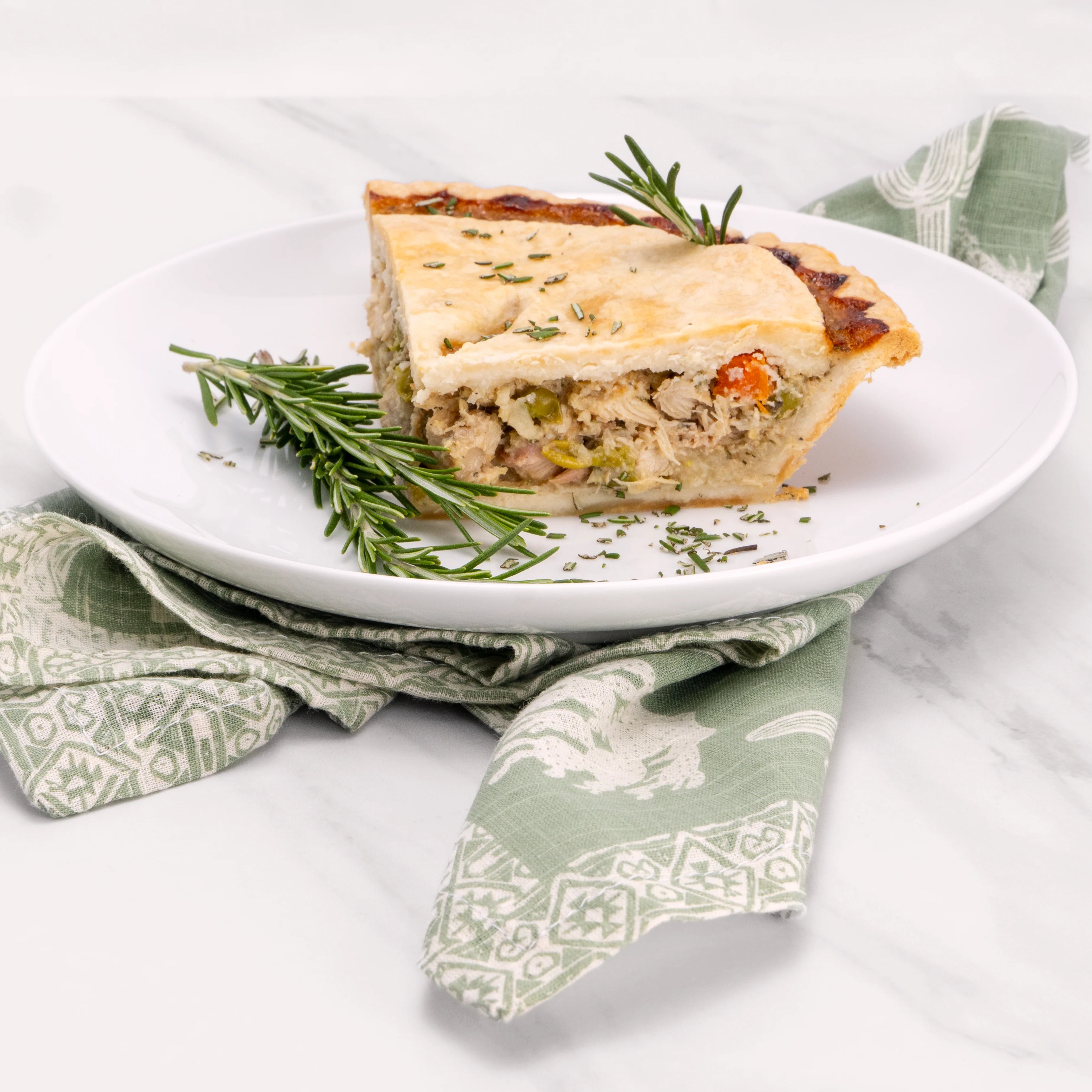 Slice of Chicken Pot Pie garnished with rosemary. 