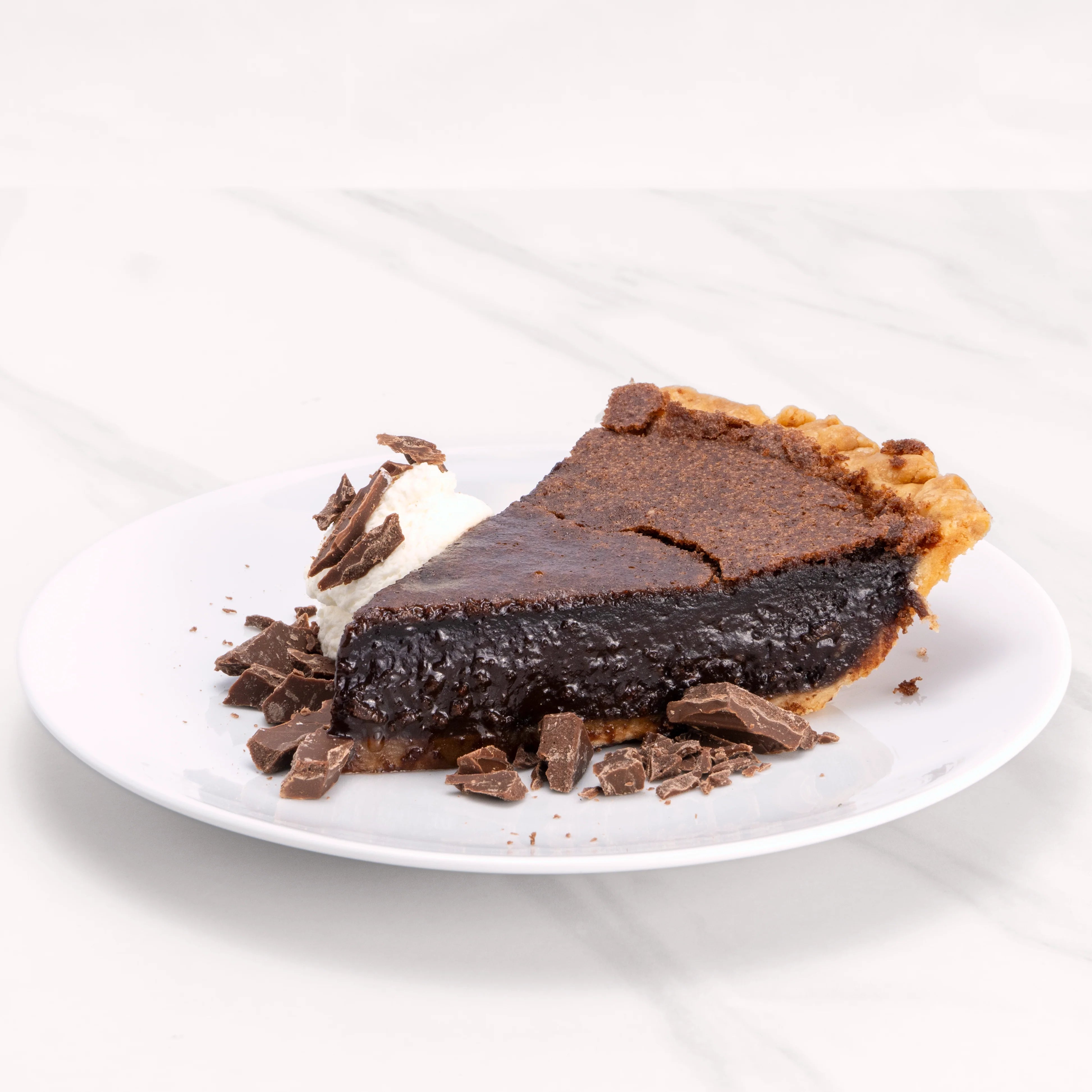Slice of Heavenly Chocolate Pie garnished with chocolate and a dollop of crème.
